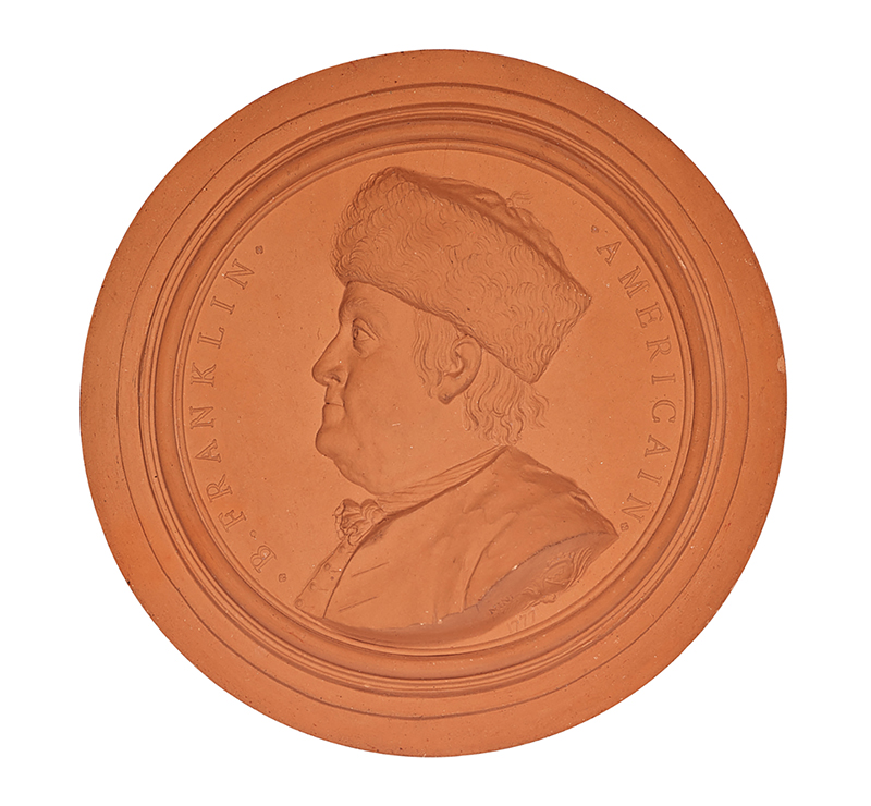 A circular, terra cotta object with a relief image of a man's head in profile