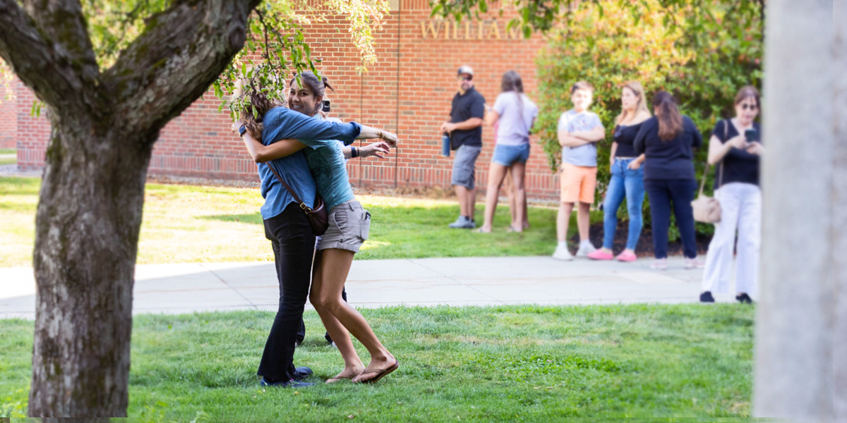A Bowdoin family says goodbye on Arrival Day with a jumping hug.