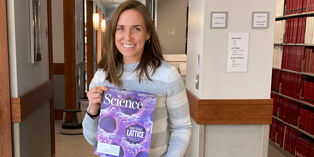 Emily Peterman holds the issue of Science magazine in the Hawthorne Longfellow Library at Bowdoin.