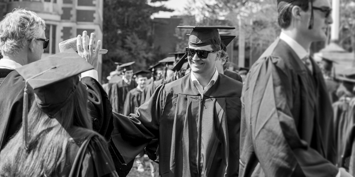Bowdoin graduates greet faculty in line at Commencement.