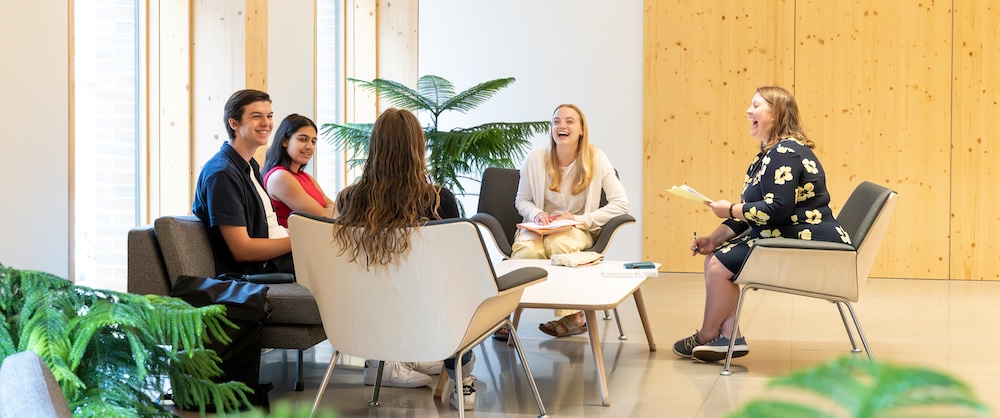 Group of students sitting at a table and chatting