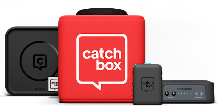 Equipment included with a Catchbox kit. The kit includes a charging dock, a 10 inch foam cube with cover and microphone, an instructor microphone, and a receiver.
