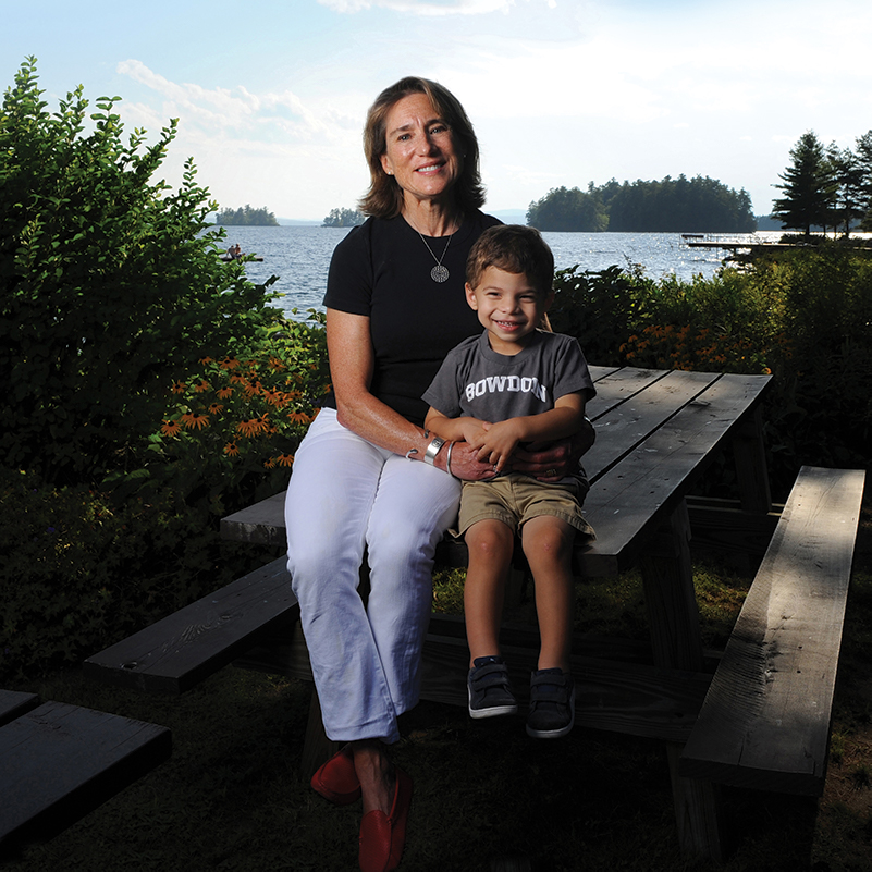 Barbara Gross and grandson sitting by the Maine coast