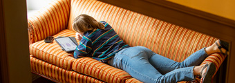 A Bowdoin student does homework on a couch.