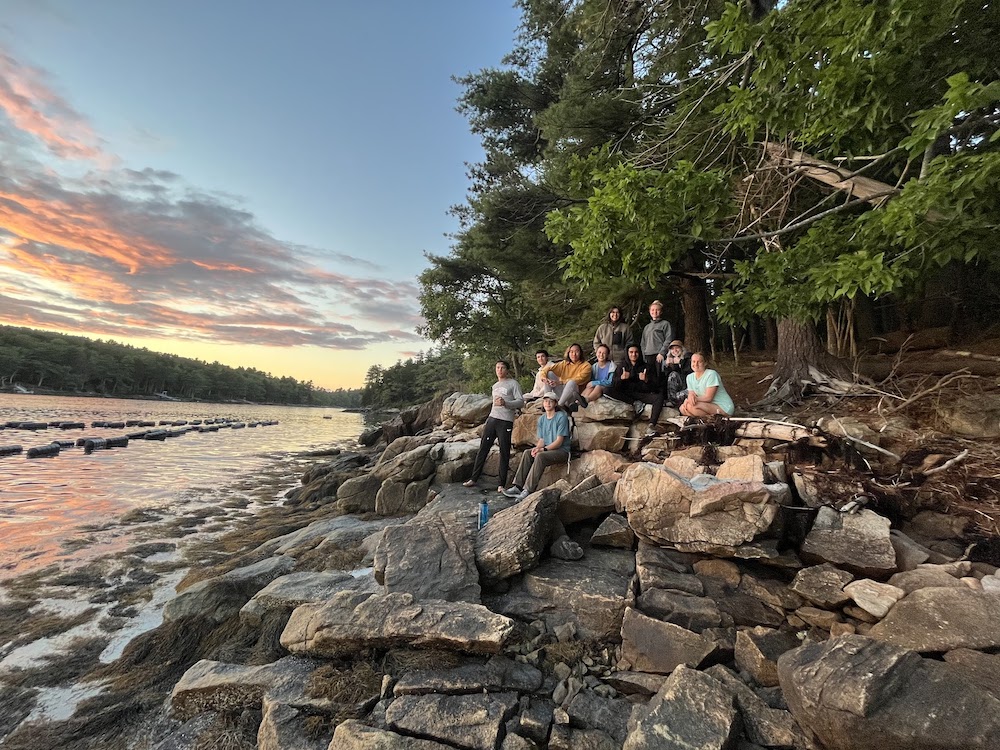 Group of students sitting on rocks by the water