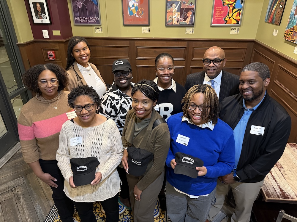 A group of Black alumni pose with Bowdoin baseball hats