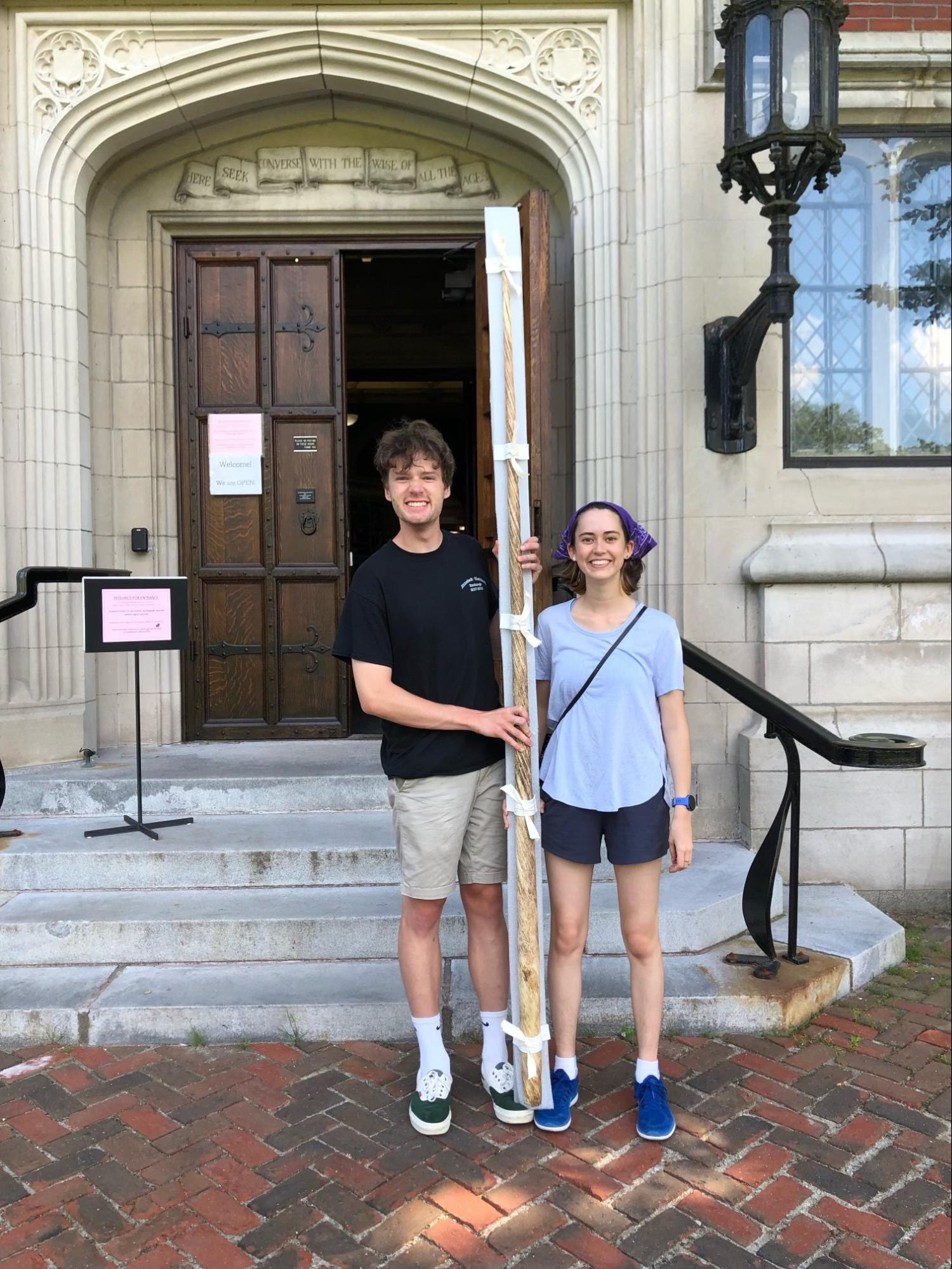 Summer interns Alex and Chapman holding narwhal tusk