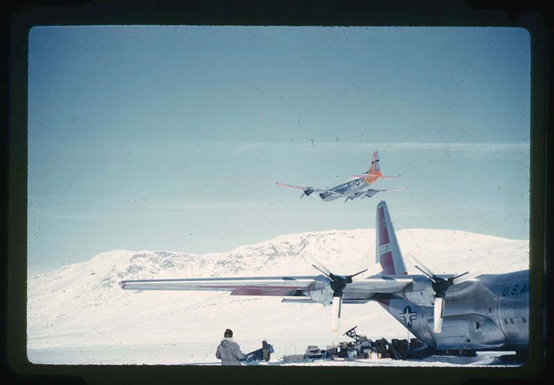 Stanley Needleman, C-54 Aircraft Flies Overhead as a Rescue Aircraft While C-130 Aircraft Lands, Centrum Lake, northeast Greenland, May 5, 1960. 35mm slide. Gift of Stanley Needleman.