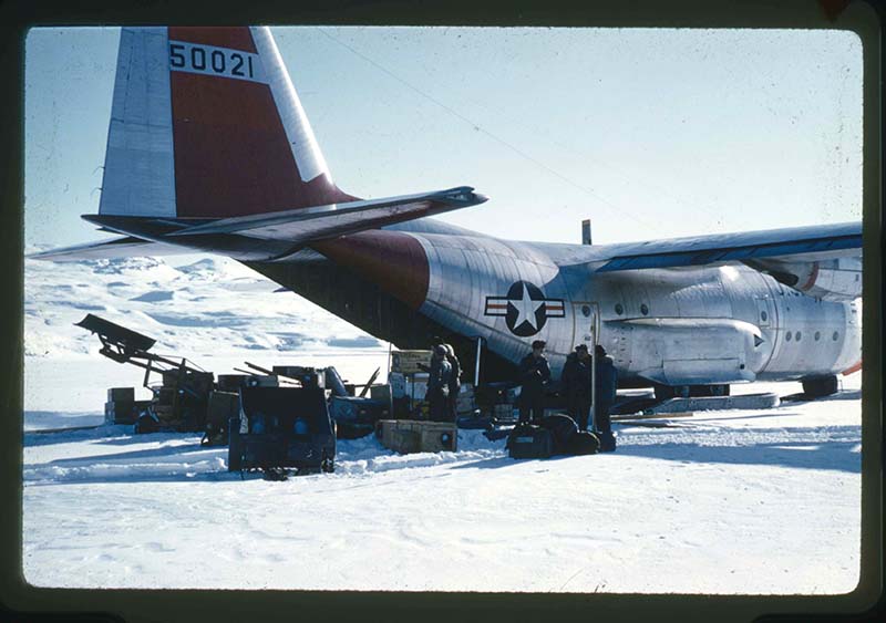 Stanley Needleman, Unloading of C-130 Aircraft of Equipment, Supplies and Vehicles in the Snow, Centrum Lake, northeast Greenland, May 5, 1960. 35mm slide. Gift of Stanley Needleman.
