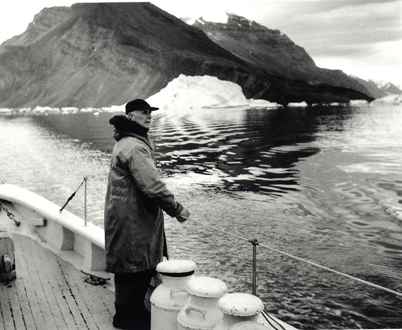 Donald MacMillan standing at the rail of the Schooner Bowdoin.