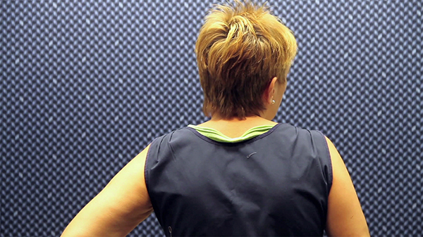 The back of a woman's head against a blue backdrop