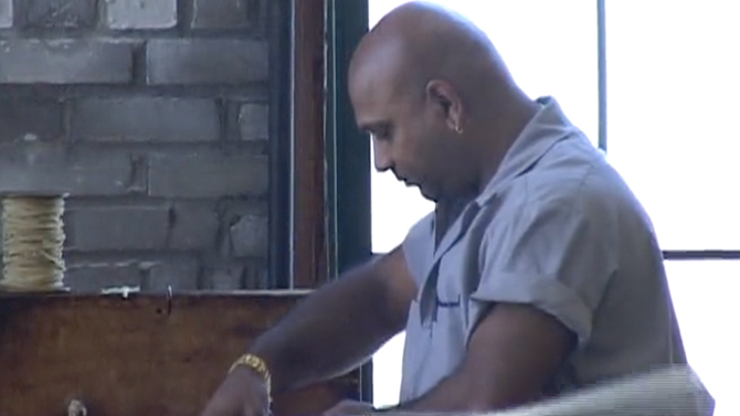 A man in a blue shirt working in a factory