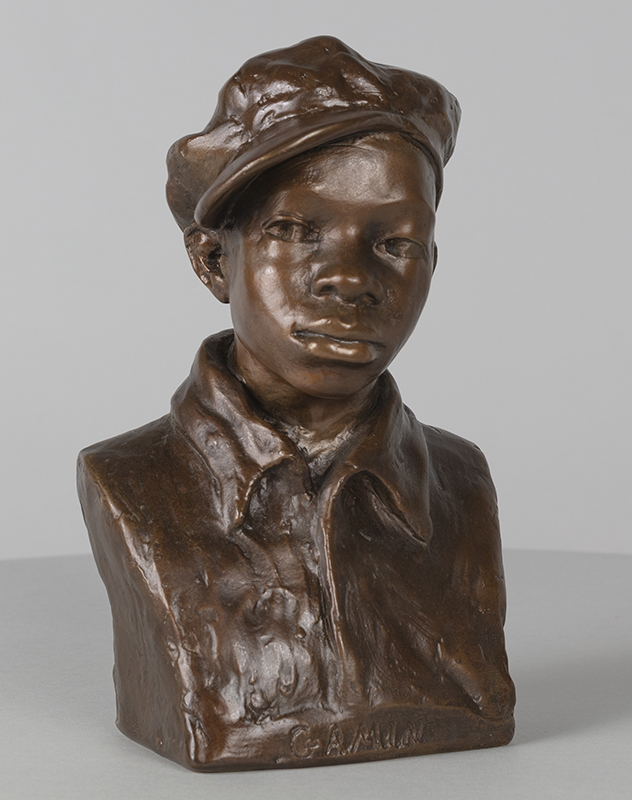 A bronze bust of a youth with a cap on his head
