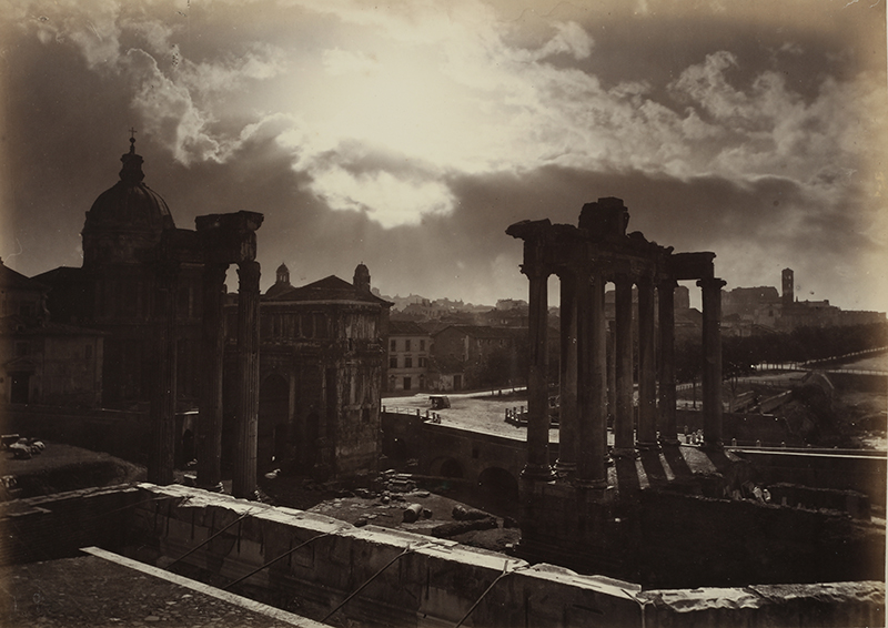 a sepia photograph of ancient ruins before a dramatic sky