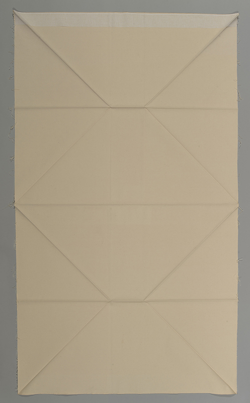 a vertical image of a coarse fabric with carefully folded lines