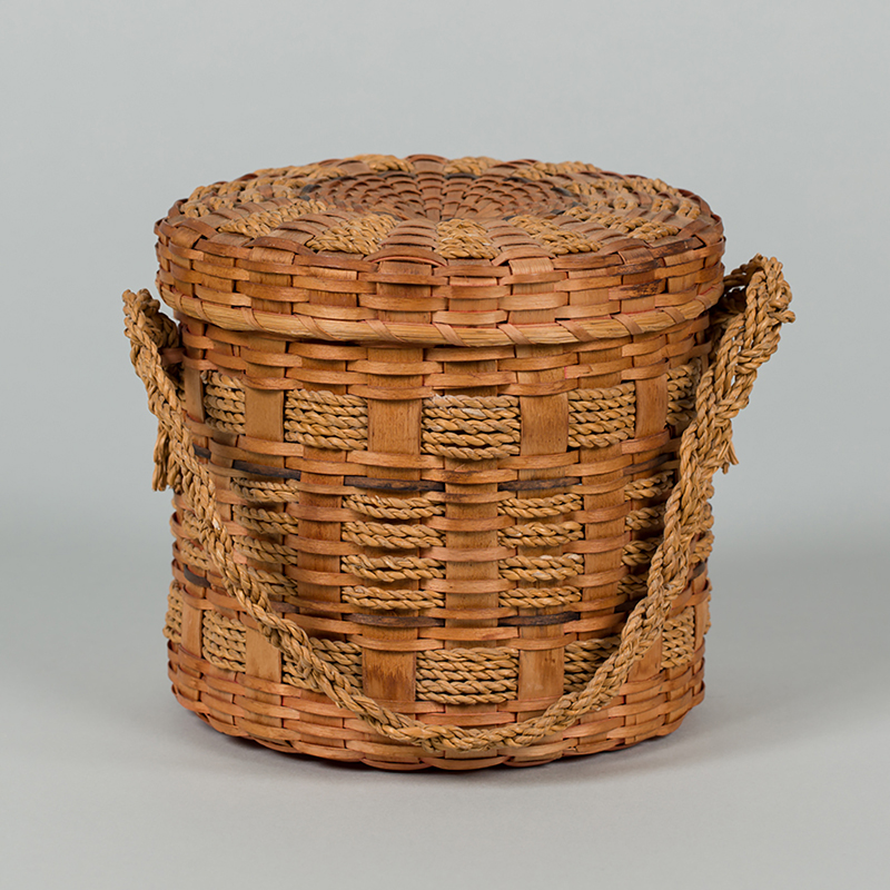a natural color weaved basket with a cover and handle