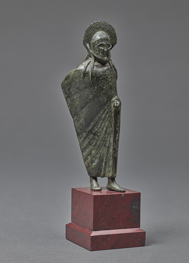 An ancient sculpture of a draped male warrior