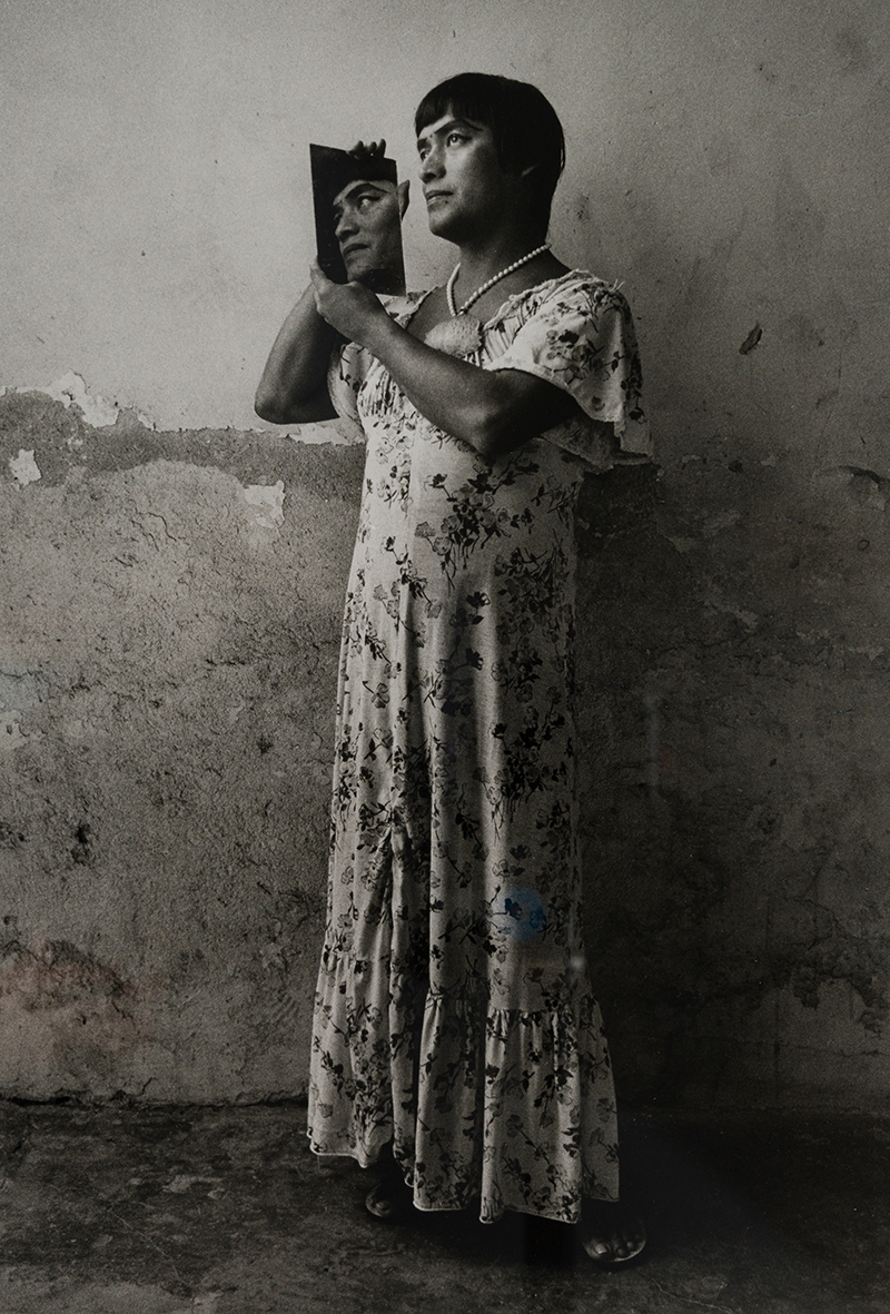 black and white photograph of a figure in a dress holding a hand mirror