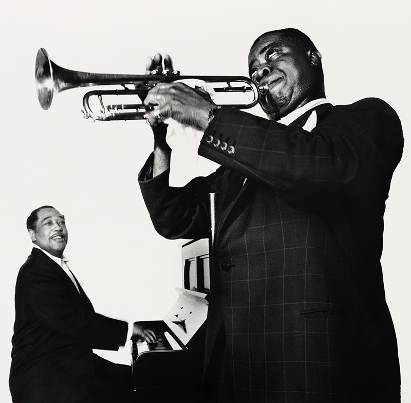 A black and white photograph of a man at a piano and a man playing a trumpet