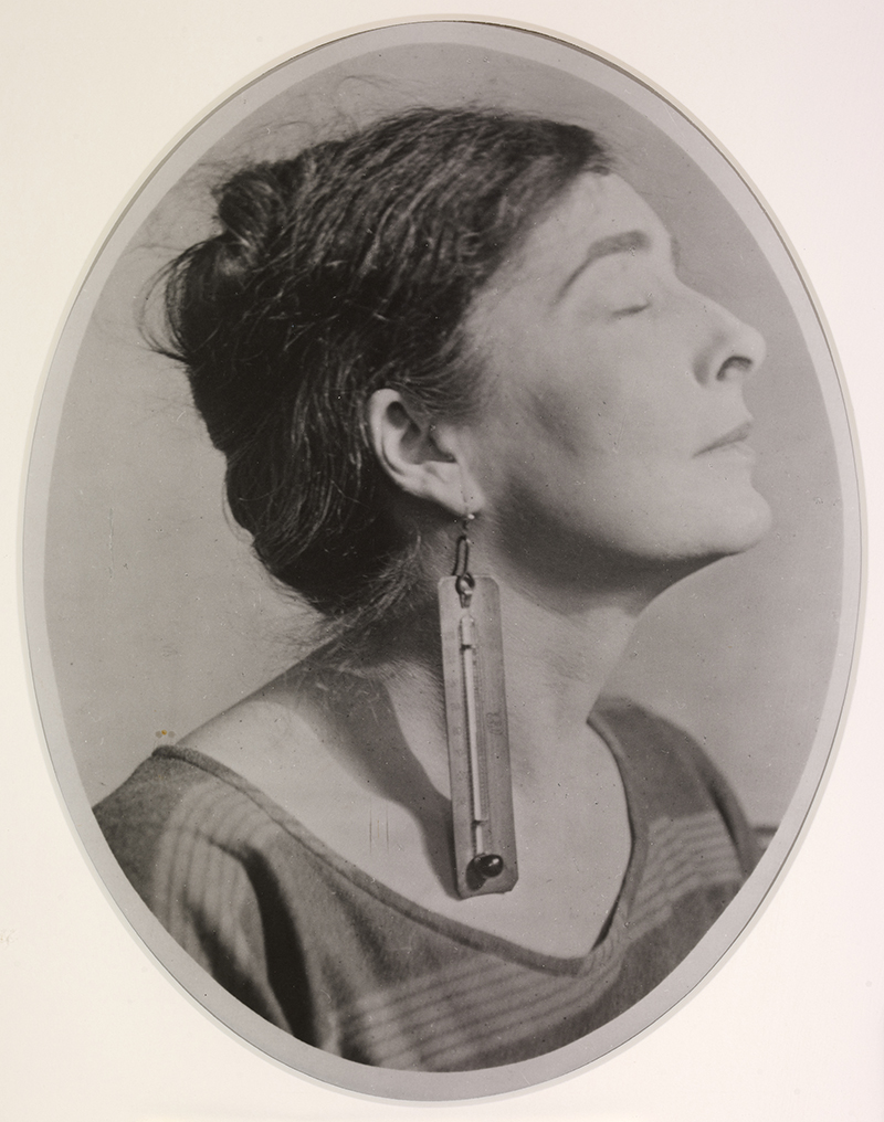A black and white photograph of a woman's face in profile, with long earring