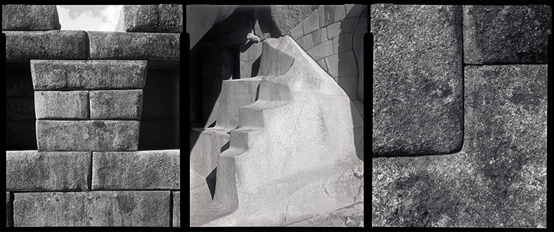 a black and white photo of a wall of square stones