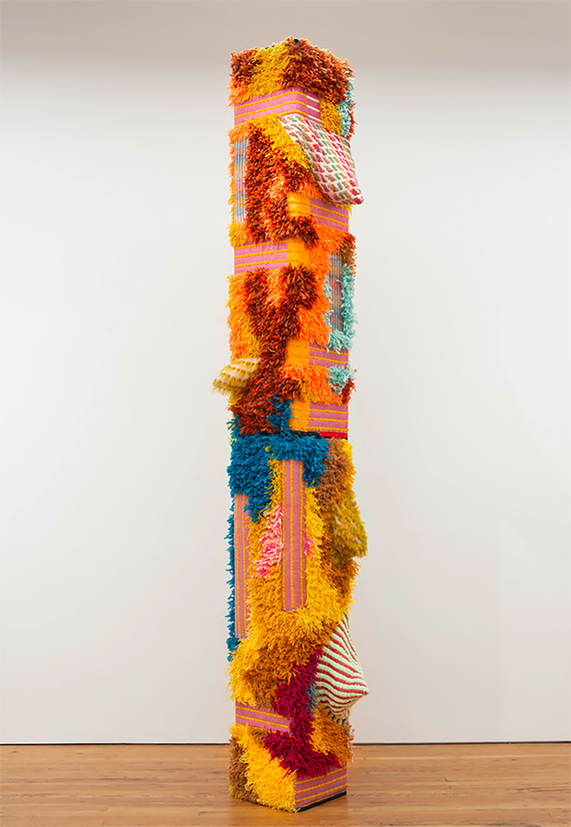 a vertical construction/sculpture with brightly colored fabrics
