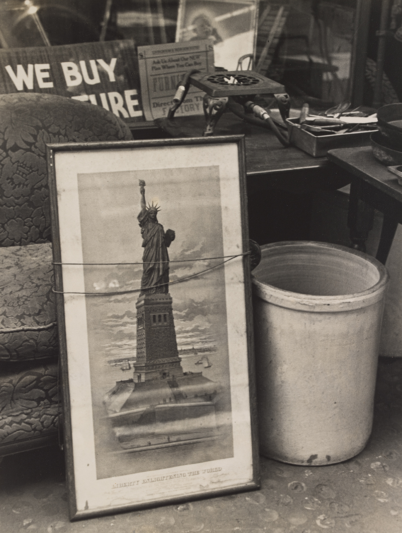 A black and white photo showing various used items, including a photo of the statue of liberty with wire wrapped around its frame