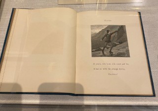 an open book with the right page showing an illustration of a young man climbing a mountain