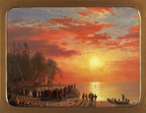 a crowd of people gather around a boat in front of a lake as the sun begins to set