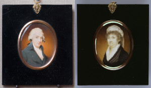 miniature portraits of a man and woman in 18th century attire inside an oval-shaped frame on a black background