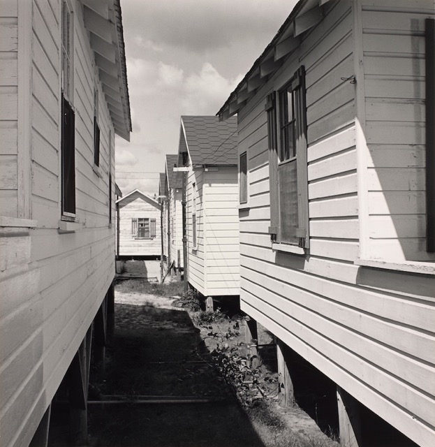 A black and white photograph shows hotel buildings in a coastal town