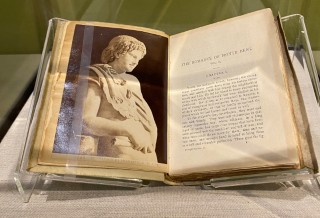 open book with left page showing an image of a marble statue