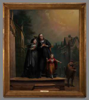 a woman, man, and child stand on a dias in a town. An additional man looks on