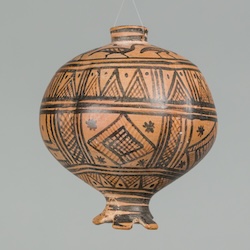 An ancient clay vessel in the shape of a pomegranate
