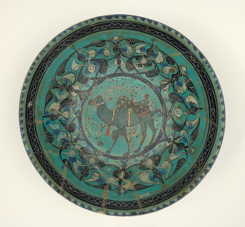 A turquoise bowl with geometric designs and the image of a camel