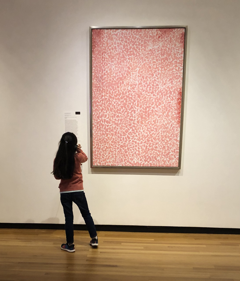 A young visitor enjoys a painting at the Museum