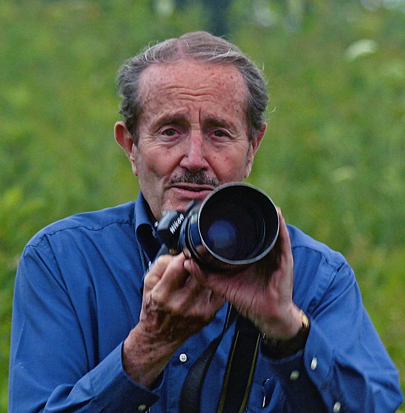 a man facing forward holding a camera