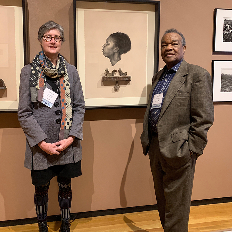 Two people standing in an art museum in front of various works of art