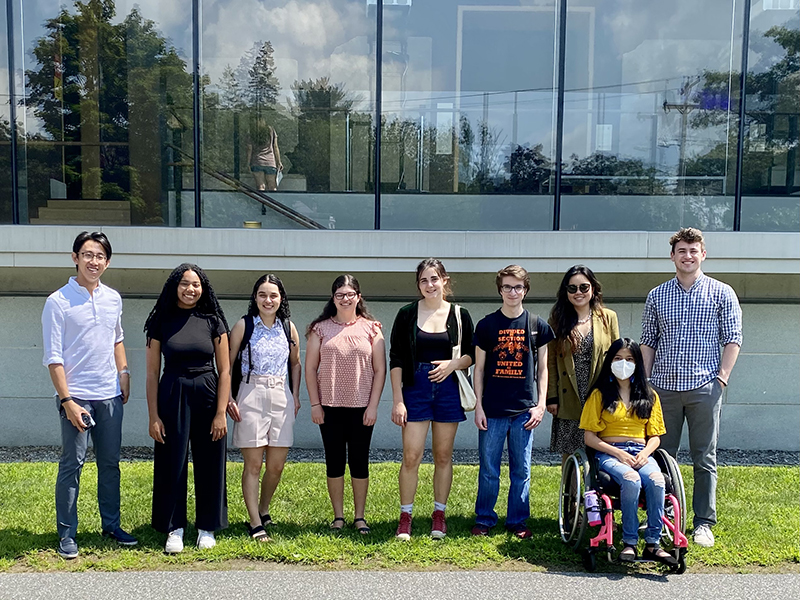 Nine people standing by the window wall of the Assyrian Gallery at the Bowdoin College Museum of Art