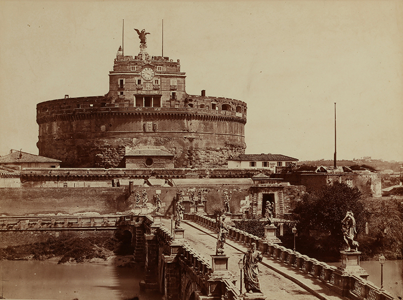 A sepia photograph showing a church on an island, with a road/bridge leading to it.