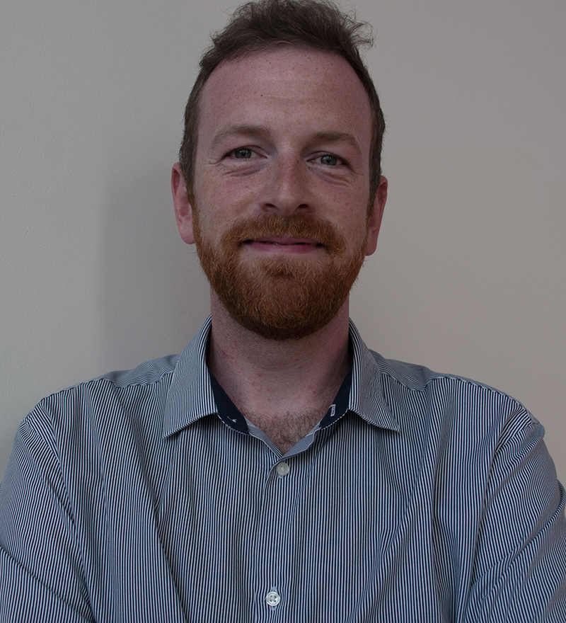 A photo of a a man with a beard, wearing a blue shrt