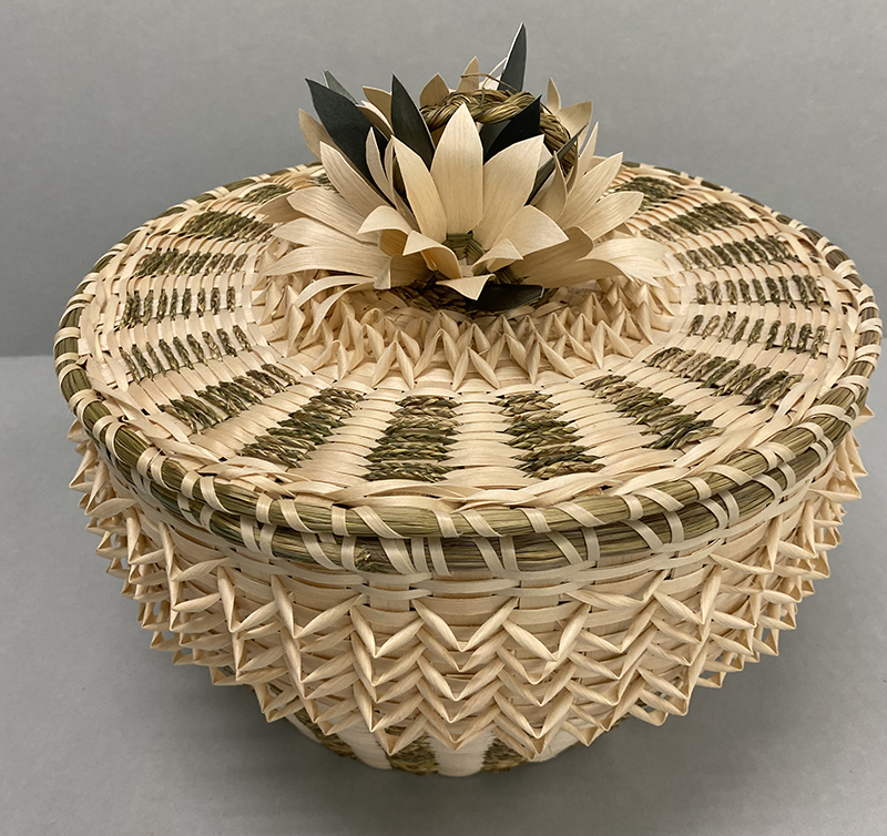 a woven basket with a floral motif on the lid