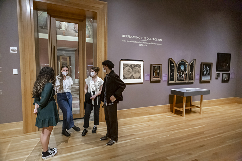 Four people enjoying a conversation in a museum gallery