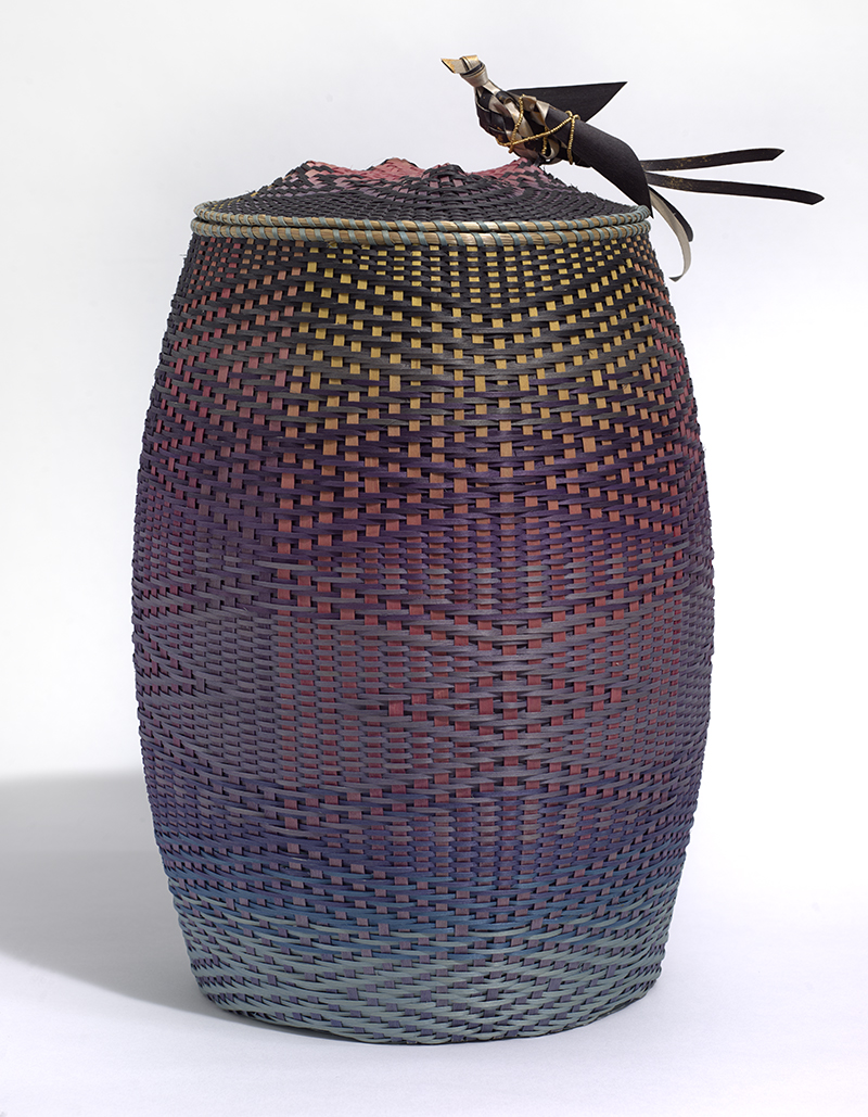 a finely woven basket with a bird on the lid