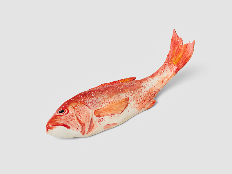 an orange-red colored ceramic fish