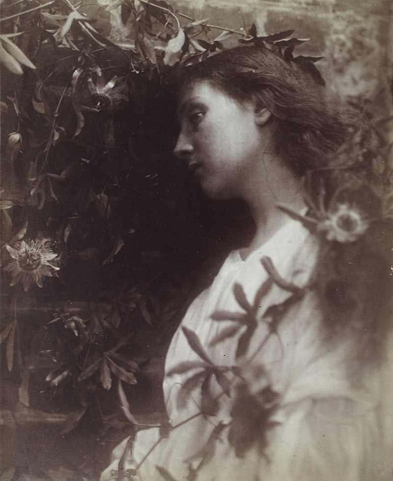 a blurred photo of a young woman in white with vegetation surrounding her.