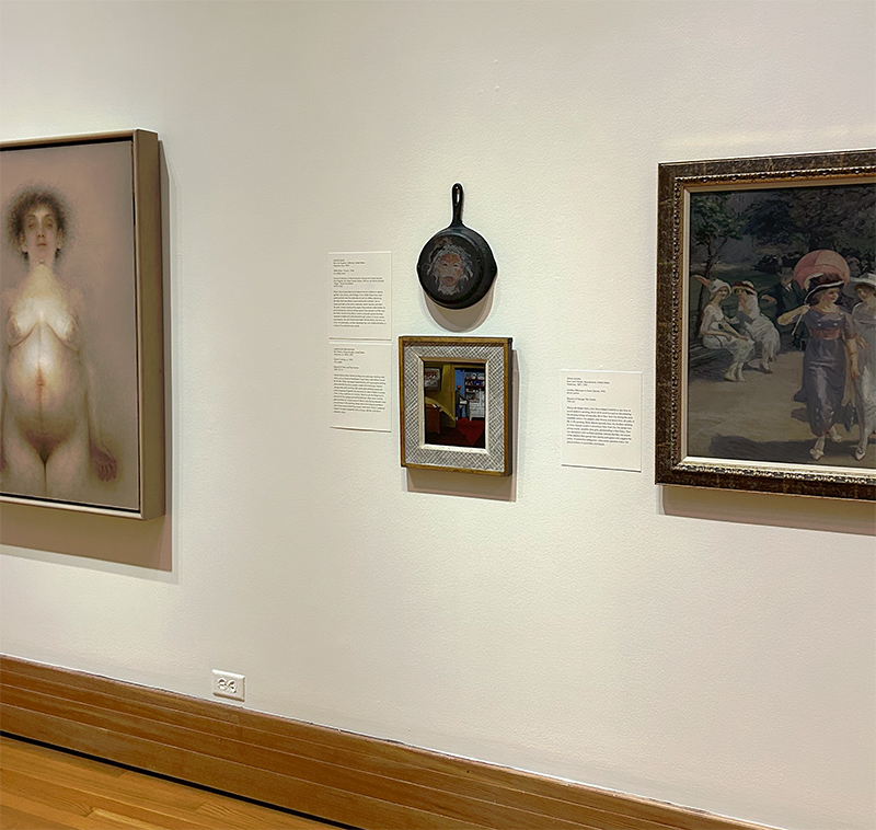 Artwork in a gallery space is hung on light colored walls