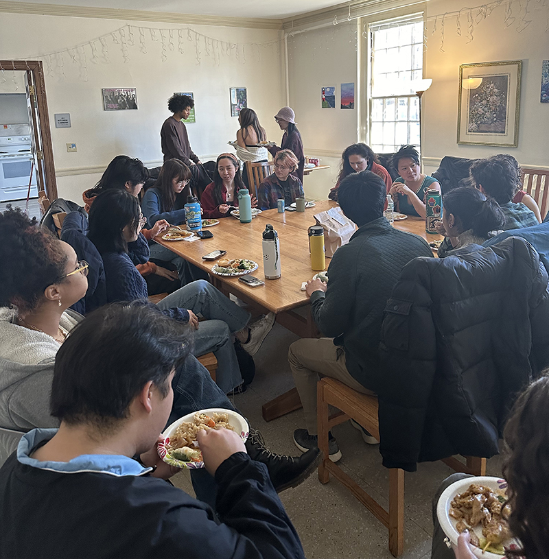 A group of people sitting near a table, eating lunch