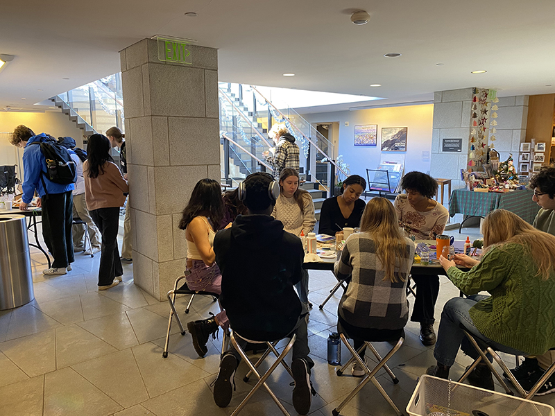 A group of college students enjoying coffee and treats in the entrance to museum