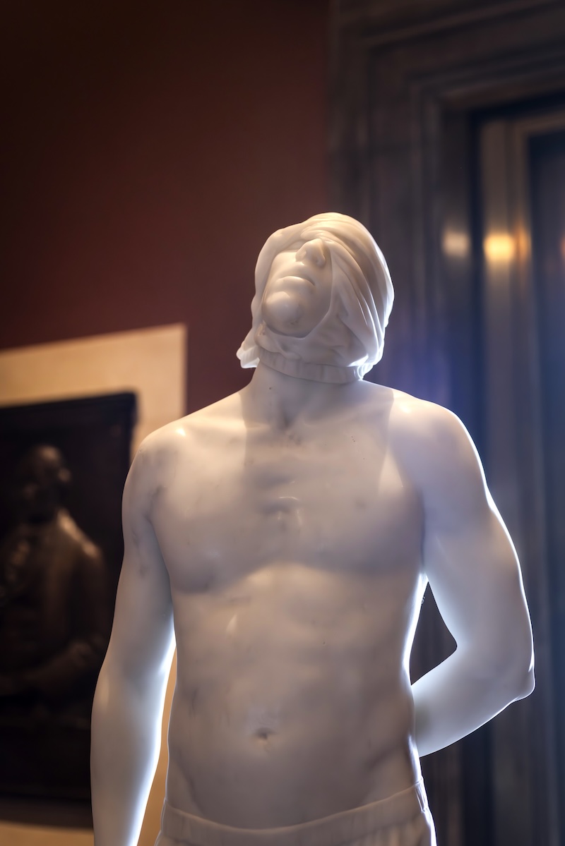A freestanding marble sculpture displayed in an art museum